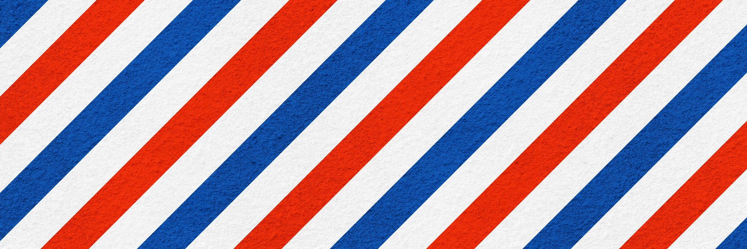 three coloured barber shop banner on coarse plaster texture